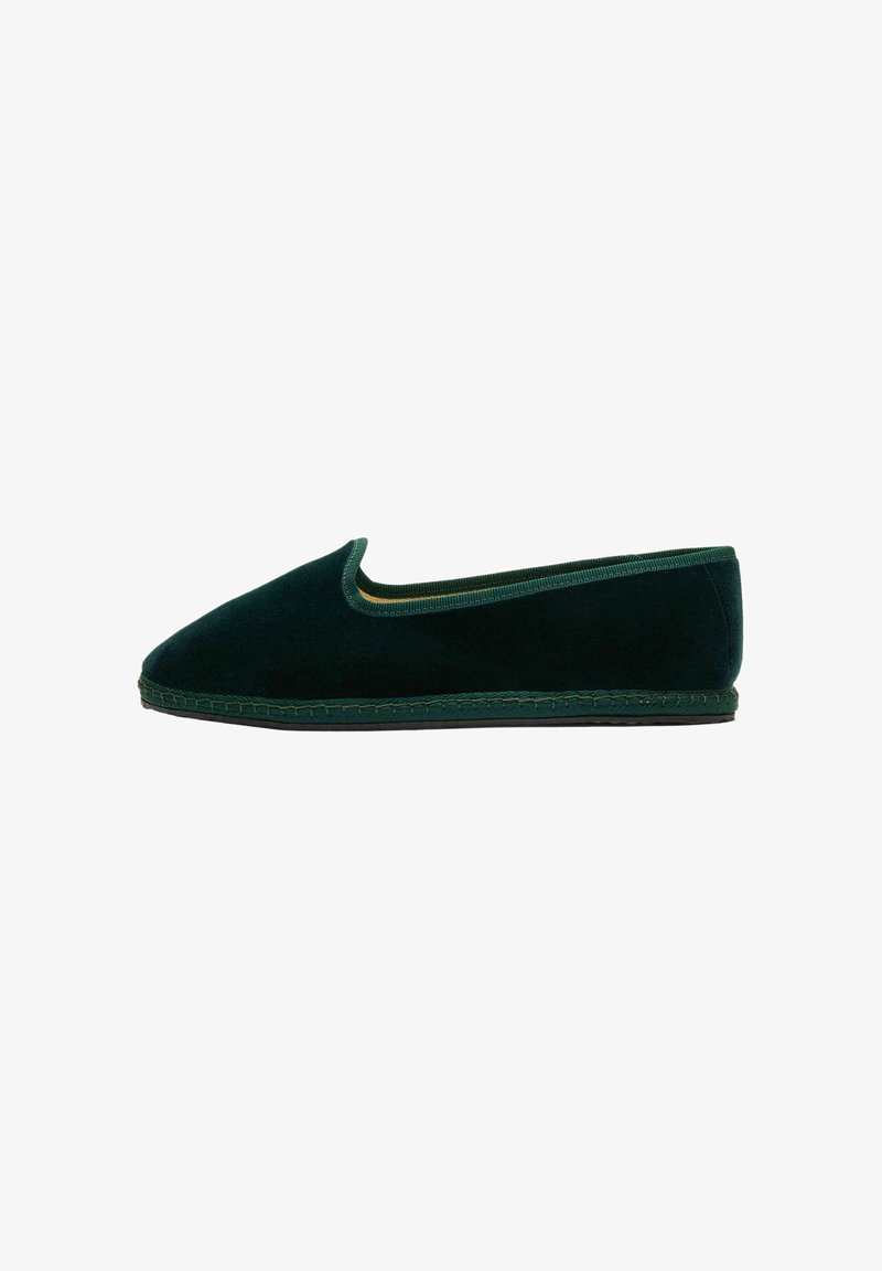 Scarpa piatta slip-on in velluto verde scuro con punta arrotondata e suola cucita, esposta su sfondo bianco, vista laterale.