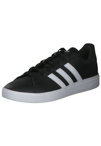 Zwarte synthetische sneakers met drie witte strepen, vlakke witte zool, ronde neus en vetersluiting aan de voorkant.