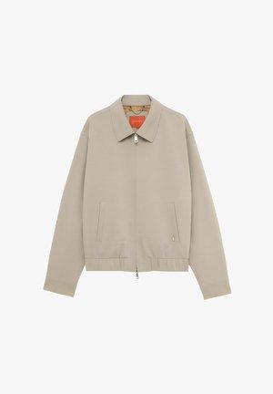 Giacca beige con zip, collo, maniche lunghe, orlo elastico e due tasche verticali a fessura sul davanti.