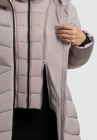 Svetlošedá puffová bunda s prešitým vzorom. Obsahuje obojsmerný zips a elegantnú, hladkú textúru. Viditeľná vnútorná vrstva, tmavšia látka.