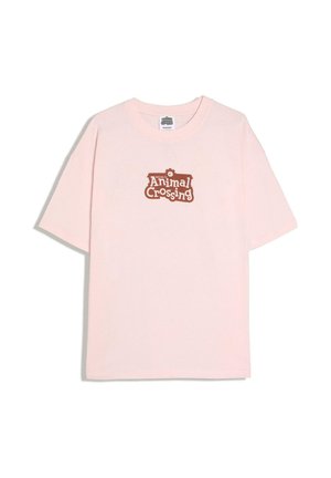 Lyserød kortærmet T-shirt med brun "Welcome to Animal Crossing" logo centreret på brystet.