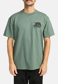 Groene katoenen t-shirt met een ronde hals, korte mouwen en een zwarte grafische print met een leeuw en tekst op het linker borstgedeelte.