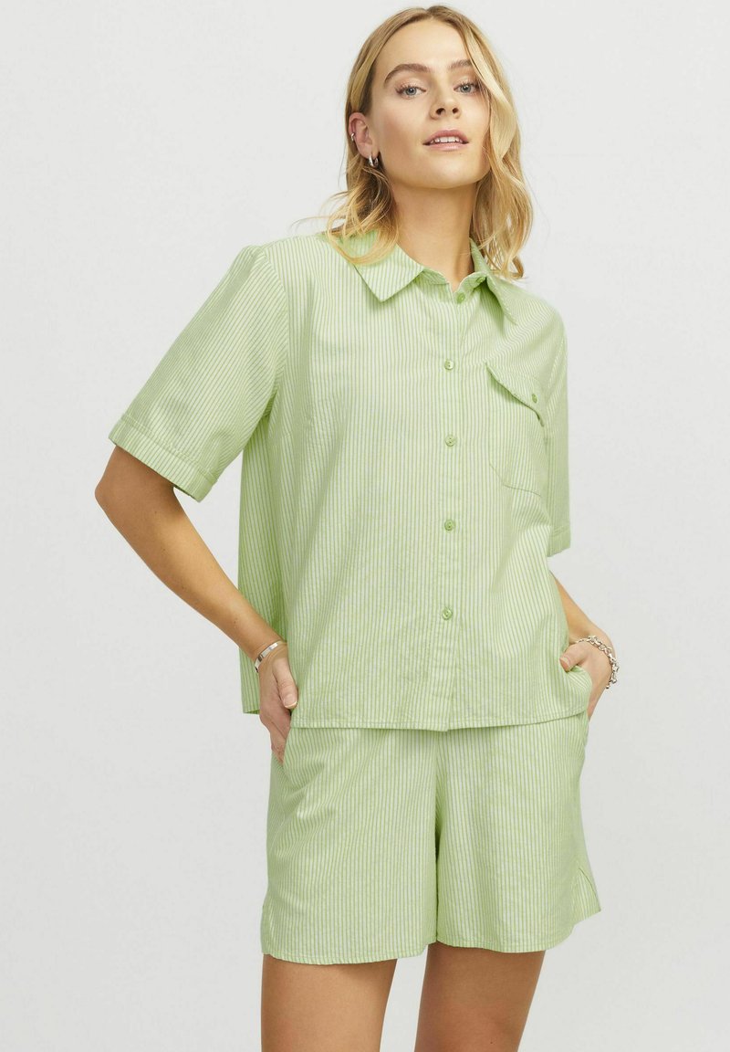 Camicetta a maniche corte a righe verdi e pantaloni coordinati realizzati in tessuto leggero. Vestibilità ampia con chiusura a bottone e dettaglio della tasca sul petto.