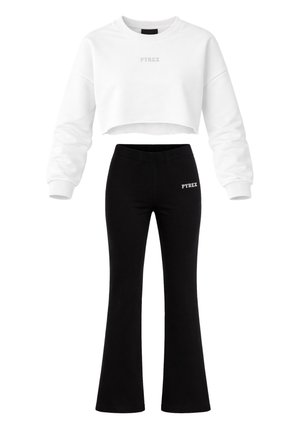 Felpa corta bianca con maniche lunghe e logo "PYREX", abbinata a pantaloni neri a zampa vita alta con un piccolo logo "PYREX".