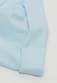 Světle modrá tkanina s hladkým povrchem, se sklopeným okrajem. Materiál vypadá měkce a je mírně pružný, ideální pro oděvy.