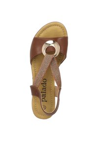 Sandal in pelle marrone con un accento metallico rotondo, fasce elastiche e soletta imbottita. Parte superiore testurizzata con dettagli cuciti.