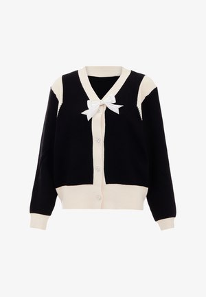 Cardigan tricotat în culori alb-negru, cu decolteu în V, cinci butoane și un detaliu cu fundiță albă la gât. Are textură ribbed și panouri contrastante.