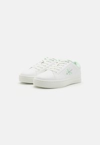 Hvite skinnsneakers med myntegrønne detaljer, rund tå, flat gummisåle og snøring. Pyntet med logo-detaljer på siden.