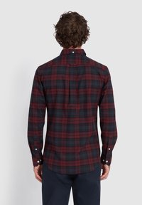 Karierte Hemd in dunklem Burgunderrot und Marineblau mit langen Ärmeln. Verfügt über einen Button-Down-Kragen und einen Rückenfalten. Weicher, leichter Stoff.