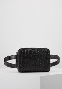 Borsa in pelle nera con stampa coccodrillo, di forma rettangolare, con chiusura a zip e tracolla regolabile. Presenta un logo impressato sul davanti.