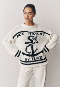 Suéter blanco de punto con diseño de ancla negra, que incluye el texto "NOT TODAY. SAILOR." y franjas negras horizontales en los puños y el dobladillo.