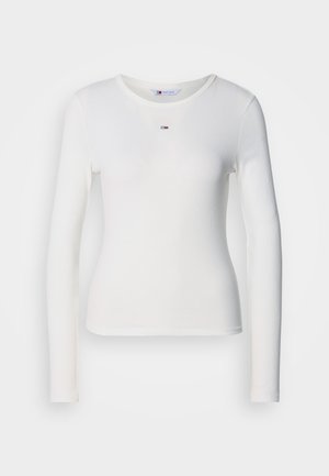 Balta ilgomis rankovėmis juostuota marškinė su apvaliomis iškirpėmis ir mažas, daugiaspalvis logotipas centre. Lygus paviršius, prigludusi siluetas.