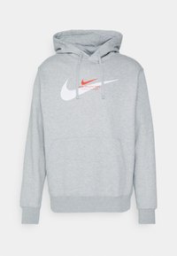 Szara bawełniana bluza z kapturem z przednią kieszenią typu kangur, regulowanym kapturem oraz logo Nike w białym i czerwonym kolorze na klatce piersiowej.