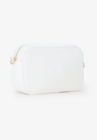 Borsa cosmetica bianca con texture trapuntata, forma rettangolare, chiusura a zip e accessori in oro. Sfumature lisce e base resistente.