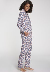 Blumiges Schlafanzug-Set mit marineblauem Grundton und rosa-weißen Blumenmustern, langärmlig und mit Seitentaschen; aus weichem Stoff mit lockerer Passform.