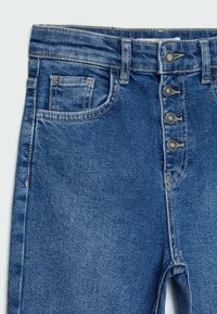 Modré denimové džíny s vysokým pasem, s knoflíkovým zapínáním, designem pěti kapes a charakteristickými detaily prošívání.