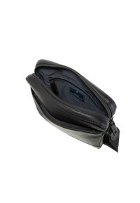 Bolso de cuero negro con cierre de cremallera, forro interior de tela y un pequeño bolsillo. Presenta una forma plana y estructurada con correa ajustable.