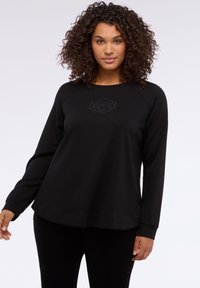 Czarna bluza z długim rękawem i okrągłym dekoltem, zdobiona haftowanym kwiatowym motywem na piersi, o luźnym, swobodnym kroju.