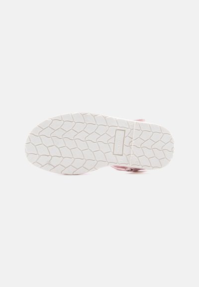 Bela gumijasta podplat rožnate superge z reljefnim vzorcem, ki spominja na liste, in napisom "Made in Spain" na loku podplata.