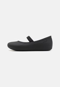 Ballet flat nera con punta tondeggiante, realizzata in materiale liscia. Presenta una cinghia diagonale e una suola testurizzata per una buona presa.