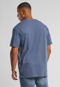 Light blue cotton t-shirt with short sleeves, crew neckline, and a relaxed fit. Smooth texture with no visible patterns.
