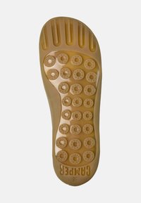 Rubber shoe sole in tan with circular tread patterns and a smooth surface, featuring a raised logo and size indicator. Rounded toe design.