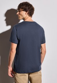 T-shirt en coton bleu marine avec un col rond et des manches courtes, présentant une texture lisse et une coupe décontractée, vue de dos.