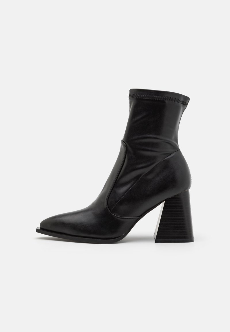Bottines noires en cuir lisse, avec un bout pointu, un contrefort de cheville élastique et un talon empilé texturé.