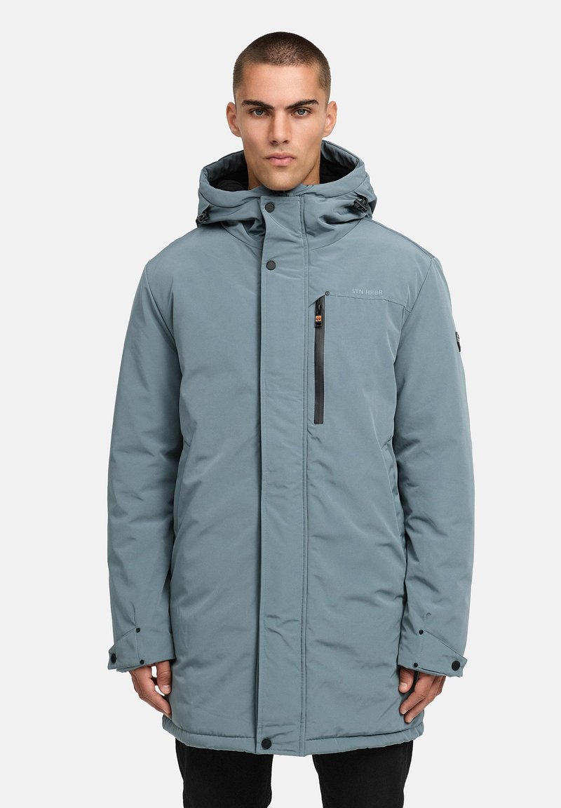 Ljusblå isolerad parkas med huva, framtida dragkedja och tryckknappar, dragkedjeförsedd bröstficka, elastiska ärmslut och sydda detaljer på tyget.