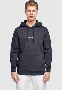 Dunkelgrauer Hoodie mit einer Fronttasche, Kapuze mit Kordelzug und kleinem weißen Logo-Text auf der Brust. Weicher Stoff.