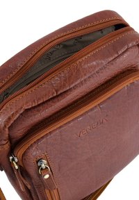 Hnědá kožená crossbody taška Venezia s dvěma zipovými přihrádky a strukturovaným koženým povrchem.