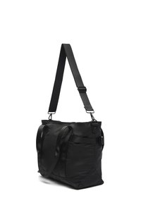 Crna najlon torba za nošenje s dvostrukim ručkama na vrhu i podesivim remenom za rame. Ima strukturu i izdržljiv materijal.