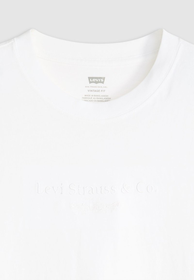 Weißes Baumwoll-T-Shirt mit einem Rundhalsausschnitt und geprägtem "Levi Strauss & Co." Logo auf der Vorderseite, mit einem Vintage-Fit-Etikett im Inneren.