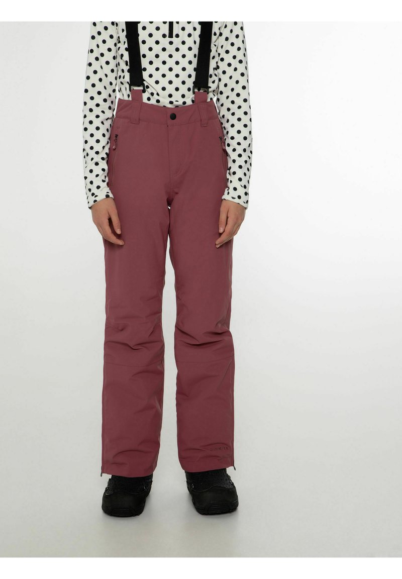 Burgundy hiihtohousut, joissa on säädettävät mustat olkaimet, vetoketjutaskut, sileä pinta ja rento leikkaus. Yhdistetty musta-valkoiseen pilkkupaitaan.