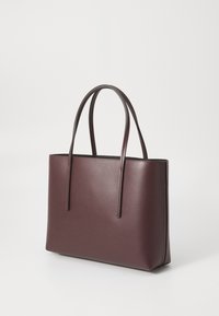 Sac à main en cuir marron avec deux longues poignées, de forme rectangulaire, texture lisse et design minimaliste. Pas de matériel ou de motifs visibles.