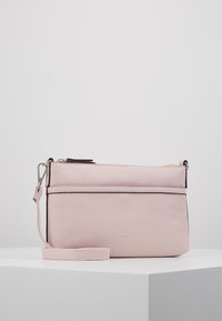 Vaaleanpunainen synteettinen olkalaukku, jossa on sileä pinta, etutasku vetoketjulla, säädettävä olkahihna ja metalliset yksityiskohdat.