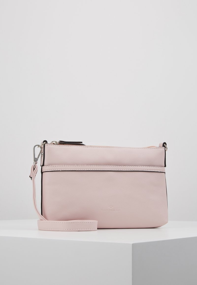 Vaaleanpunainen synteettinen olkalaukku, jossa on sileä pinta, etutasku vetoketjulla, säädettävä olkahihna ja metalliset yksityiskohdat.