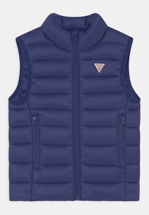Veste sans manches matelassée bleu marine avec fermeture éclair à l'avant, deux poches latérales zippées et un petit logo triangulaire sur la poitrine.