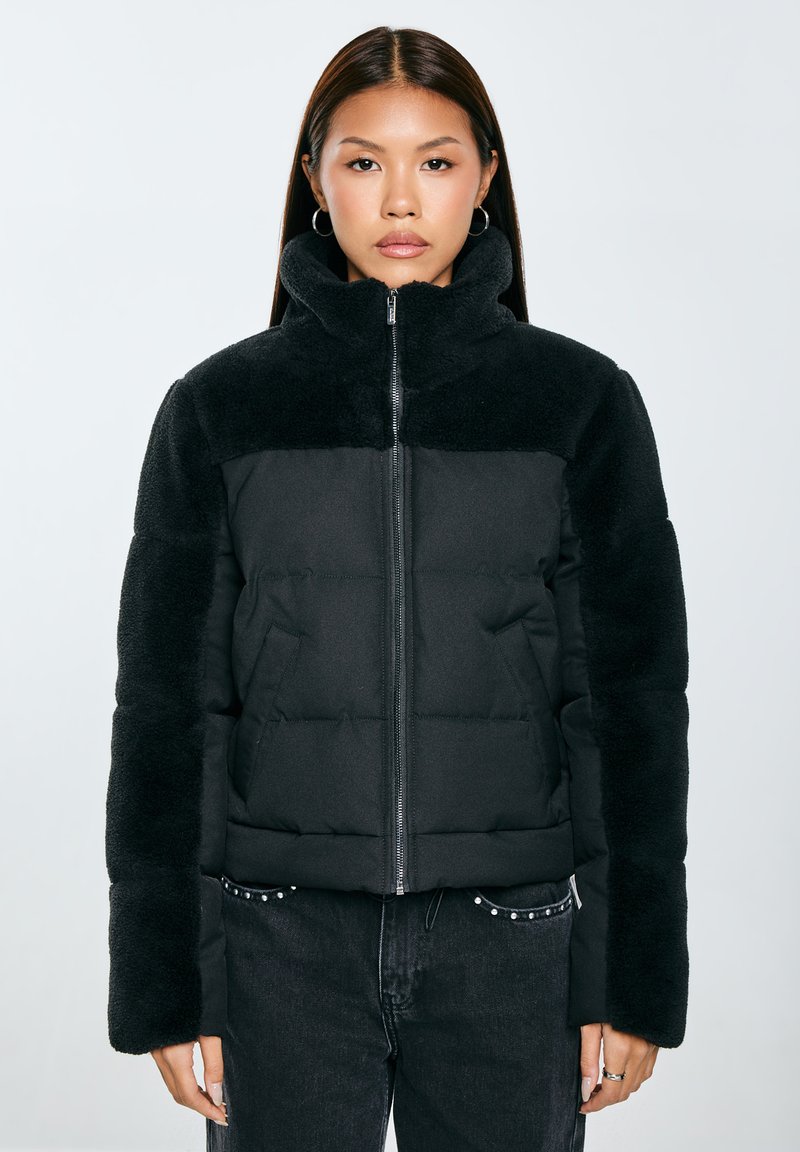 Černá zimní bunda s měkkým fleecovým límcem a rukávy, zipovým uzávěrem a prošívaným designem se bočními kapsami.