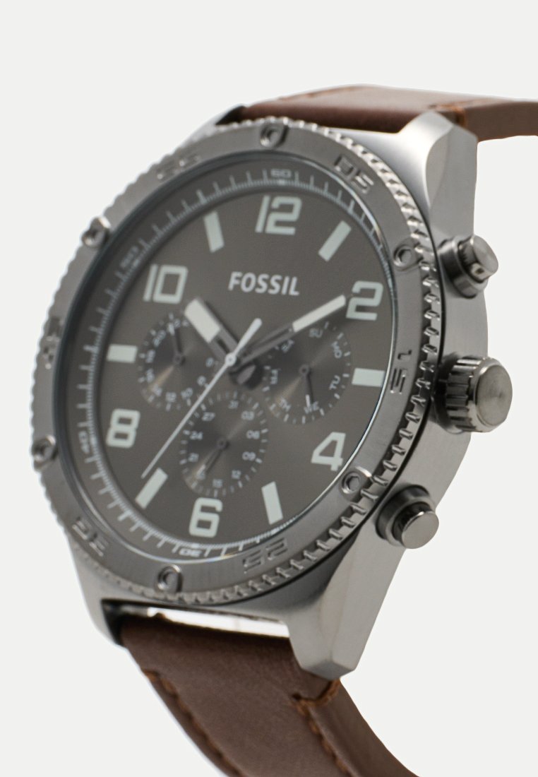 Zegarek Fossil z szarym cyferblatem, białymi cyframi, trzema subcyferblatami, stalową kopertą i brązowym skórzanym paskiem.