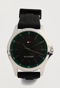 Στρογγυλό ασημένιο ρολόι χειρός με μαύρο καντράν, πράσινο δακτύλιο λεπτών, μαύρο λαστιχένιο λουράκι και ασημέ νιους δείκτες ώρας, δείχνει ώρα 9:08:39.