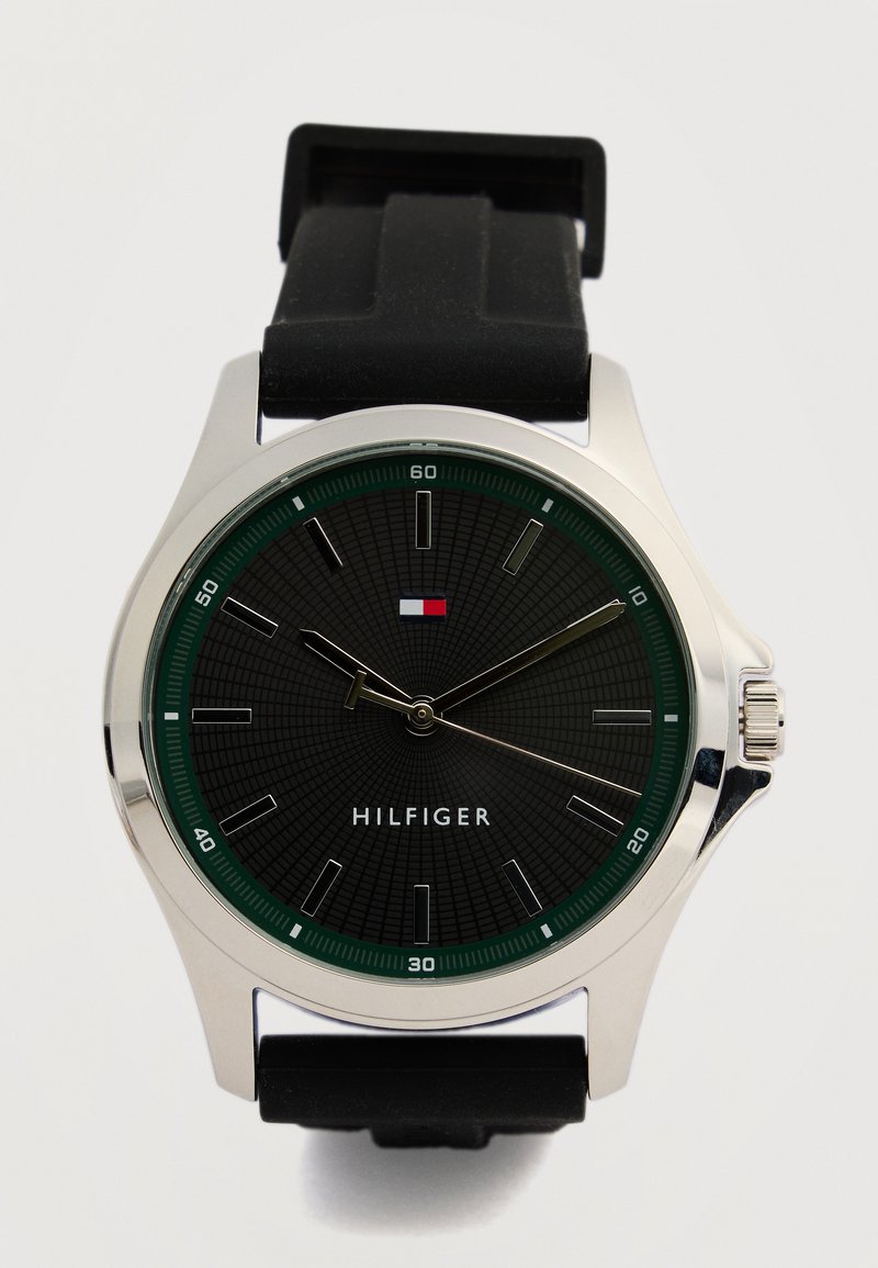 Στρογγυλό ασημένιο ρολόι χειρός με μαύρο καντράν, πράσινο δακτύλιο λεπτών, μαύρο λαστιχένιο λουράκι και ασημένιους δείκτες ώρας, δείχνει ώρα 9:08:39.