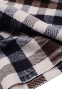 Tessuto di lana scozzese caratterizzato da grandi quadri nei toni del blu, grigio e marrone, con una texture morbida e un motivo di trama visibile.