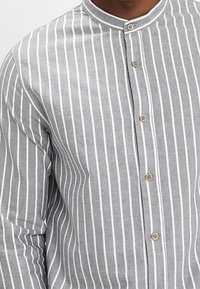Camicia a righe grigie in cotone con colletto alla cinese, caratterizzata da righe verticali bianche e bottoni con finitura naturale.