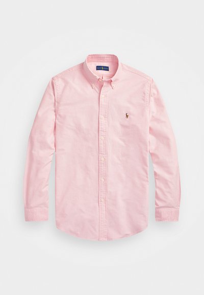 Gaiši rozā garām piedurknēm pogājama krekla no kokvilnas auduma. Ar klasisku apkakli, pogu aprocēm un nelielu izšūtu logotipu uz krūšu.