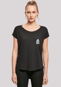 Camiseta negra de manga corta con cuello redondo, que presenta un diseño de bolsillo blanco con rayas horizontales y un detalle de logo.