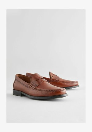 Bruine leren instappers met een moccasinontwerp, voorzien van gestikte accenten, een platte rubberen zool en een sierlijke, afgeronde teenvorm.