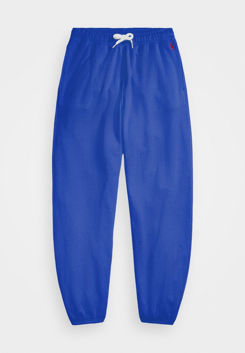 Blå sweatpants med elastisk midja, vit dragsko och blixtlås vid vristerna. Tillverkade av mjukt material med en liten logotyp på sidan.