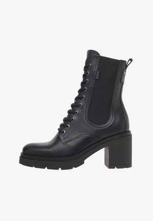 Schwarze Lederstiefelette mit einem klobigen Absatz, Schnürung vorne und elastischen Seiteneinsätzen, ausgestattet mit minimaler Naht und einer strukturierten Oberflächengestaltung.