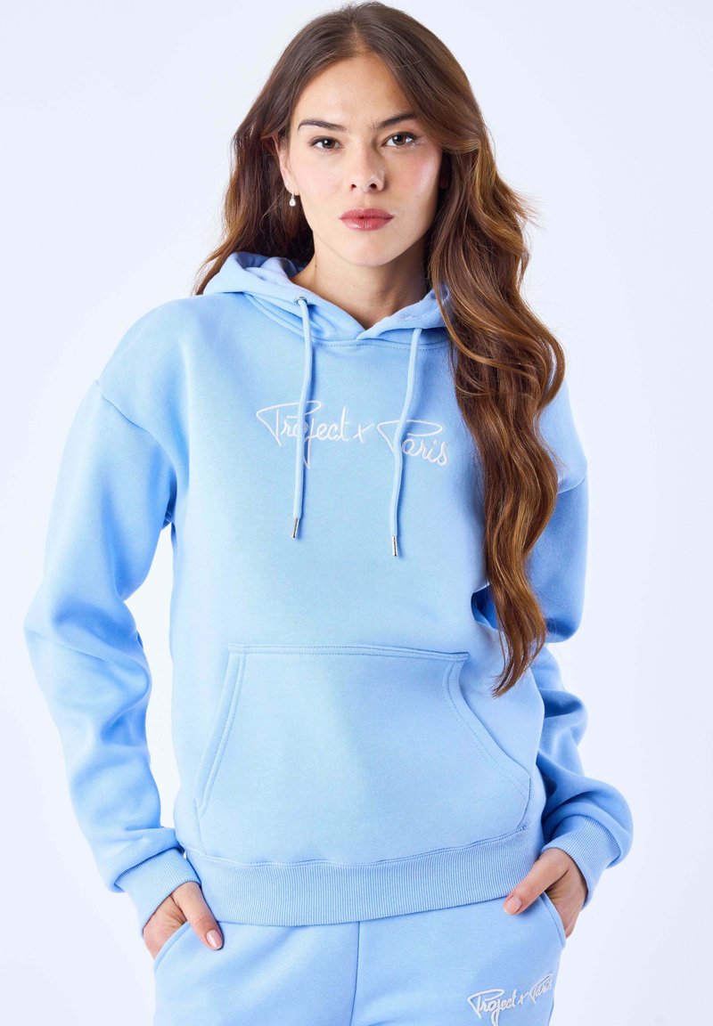 Sweat à capuche bleu clair en tissu doux, doté d'une poche kangourou, de poignets côtelés et d'un logo brodé en blanc sur le devant.